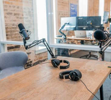 two black headphones on brown wooden table