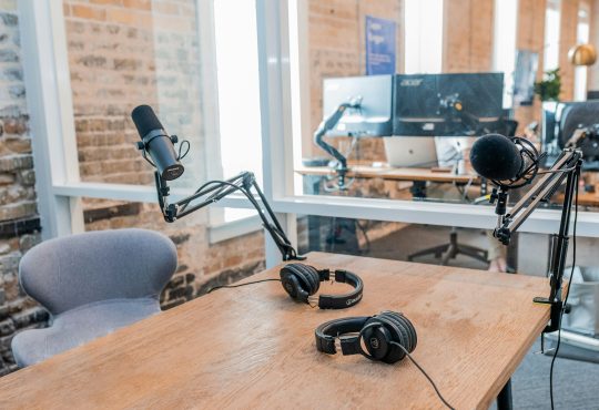 two black headphones on brown wooden table