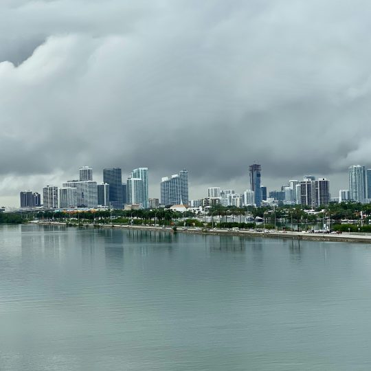 city skyline across body of water under cloudy sky during daytime