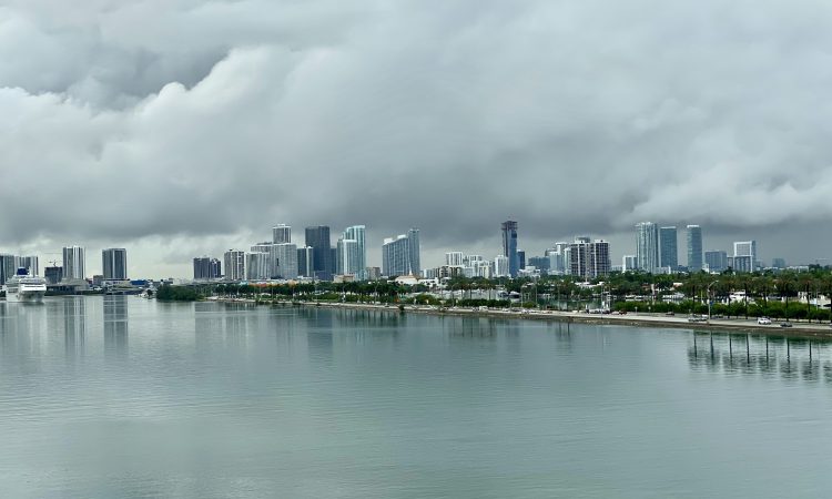 city skyline across body of water under cloudy sky during daytime
